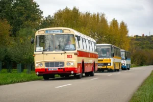 Tři vozy konvoje, v pořadí ŠM 11, LC 735, C 734, jsou zachyceny na silnici mimo obec.